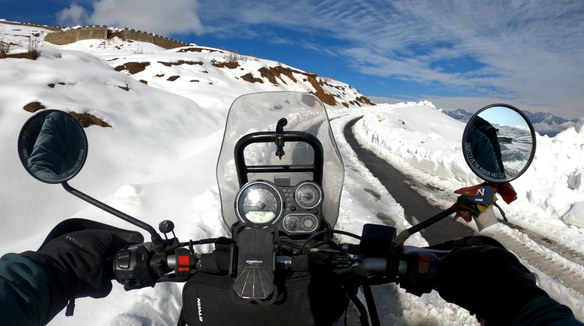 A mountain road seen over the handlebars of a motorbike